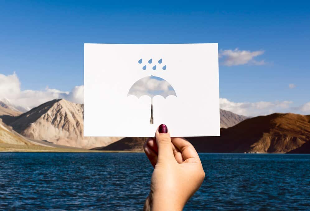 Hand holding paper with umbrella-shaped hole